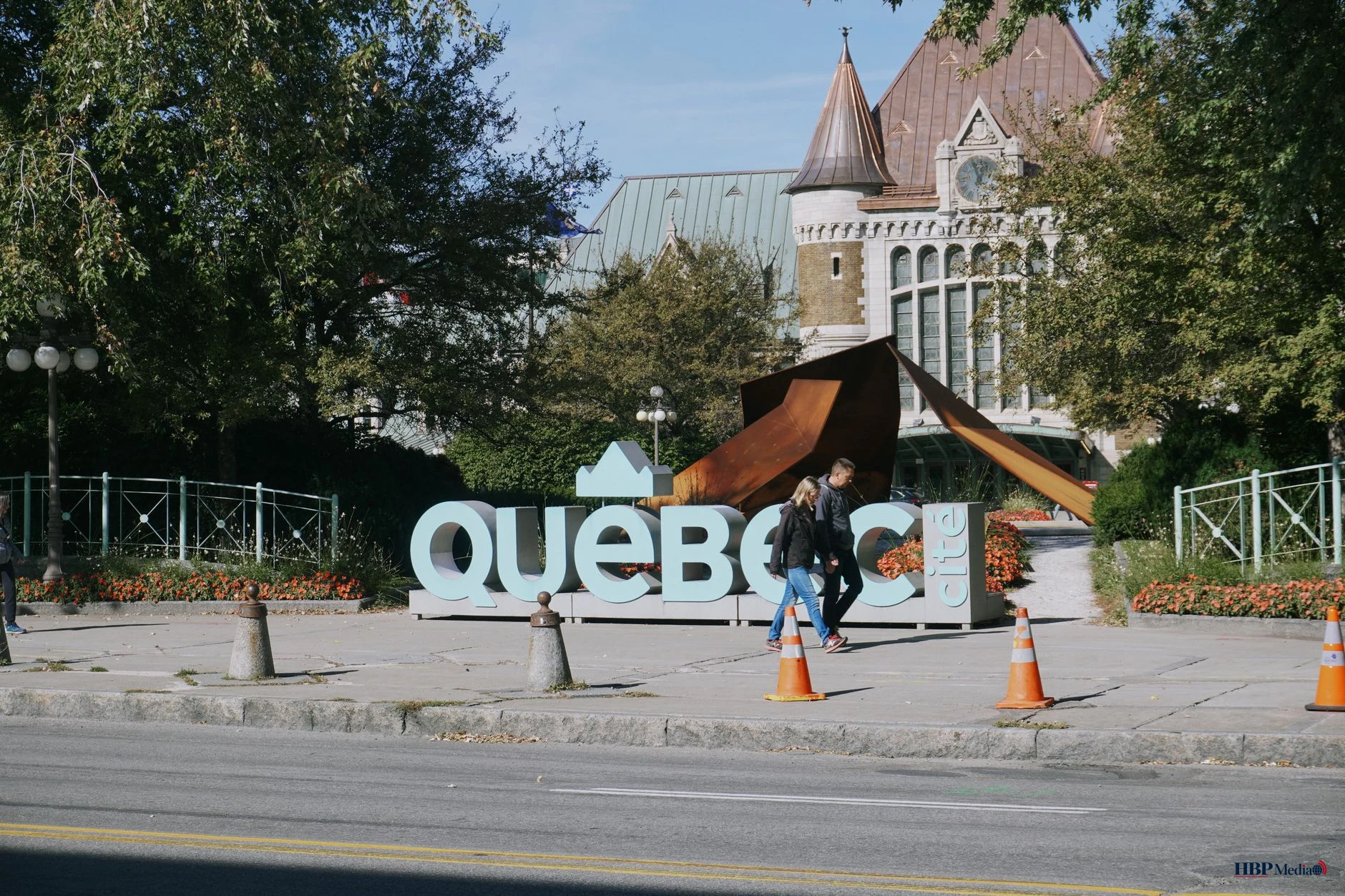 tourists walking near iconic quebec sign
