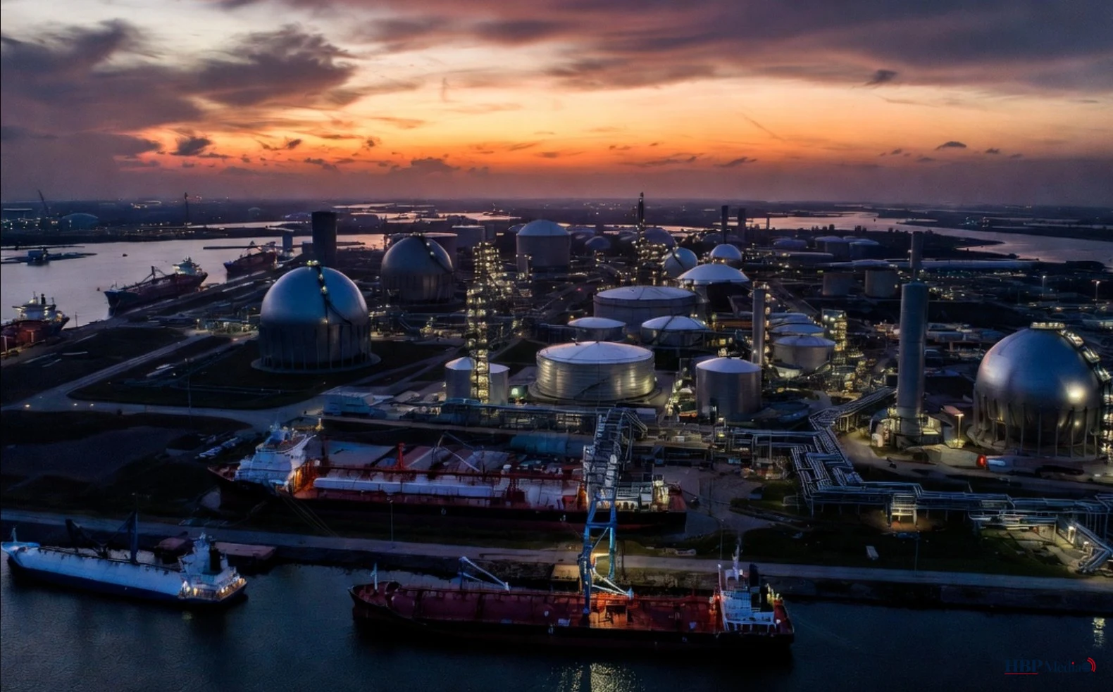 Luchtfoto van een LNG-terminal in de Rotterdamse haven met gastankers en opslagtanks in de schemering