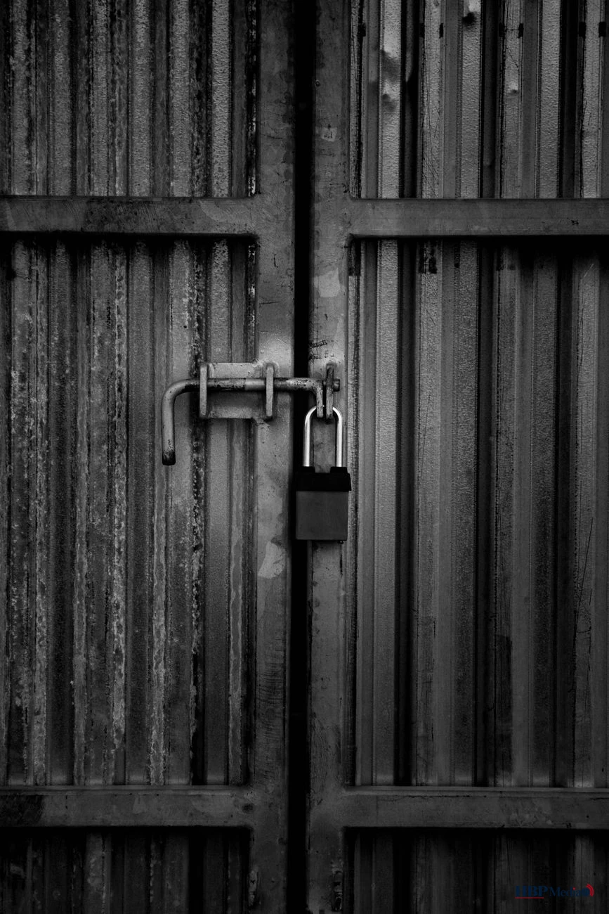 grayscale photo of padlock on door