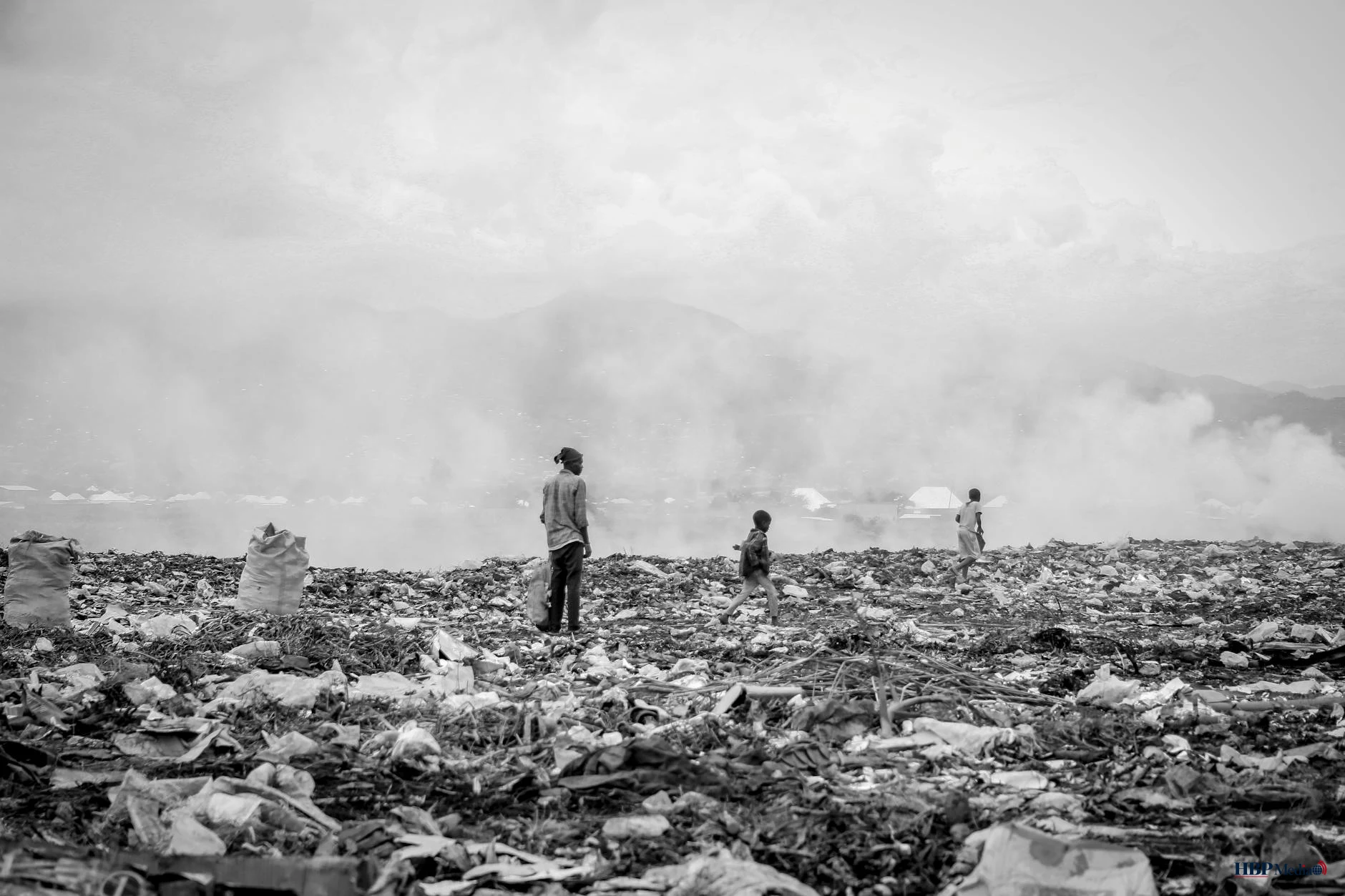 grayscale photo of people in the landfill site