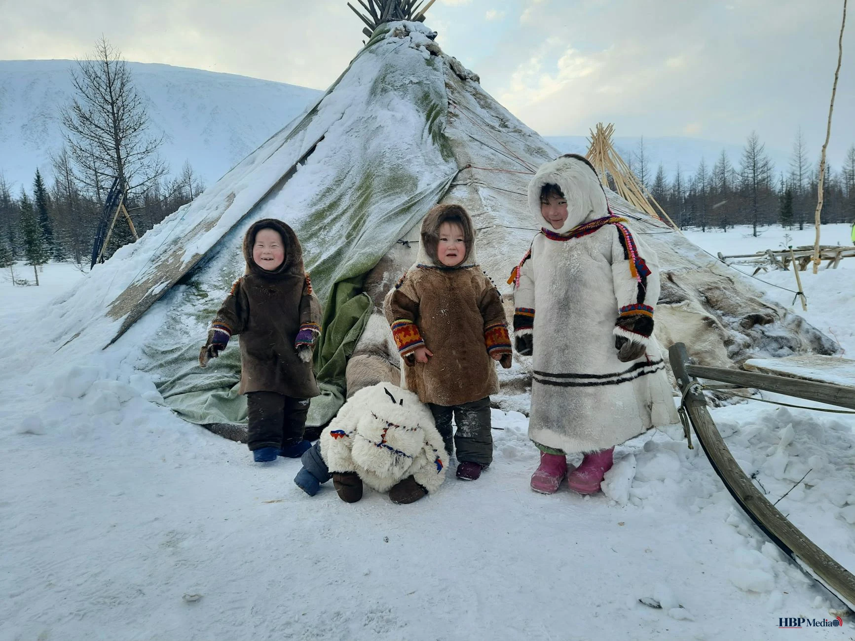 a group of children wearing parkas beside a tupik