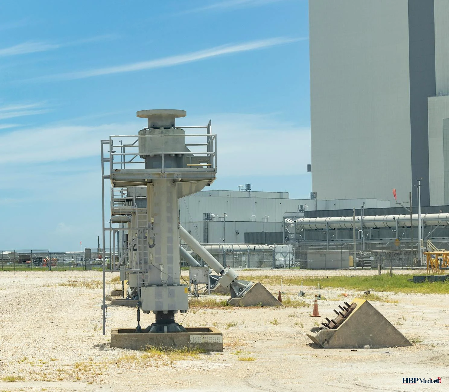 Een boorplatform voor gaswinning in een Nederlands landschap onder een grijze lucht.