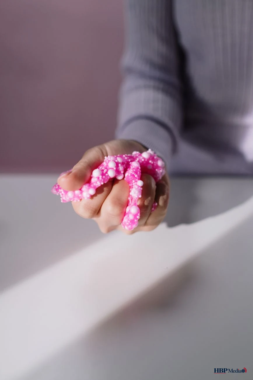close up shot of a person holding a pink slime