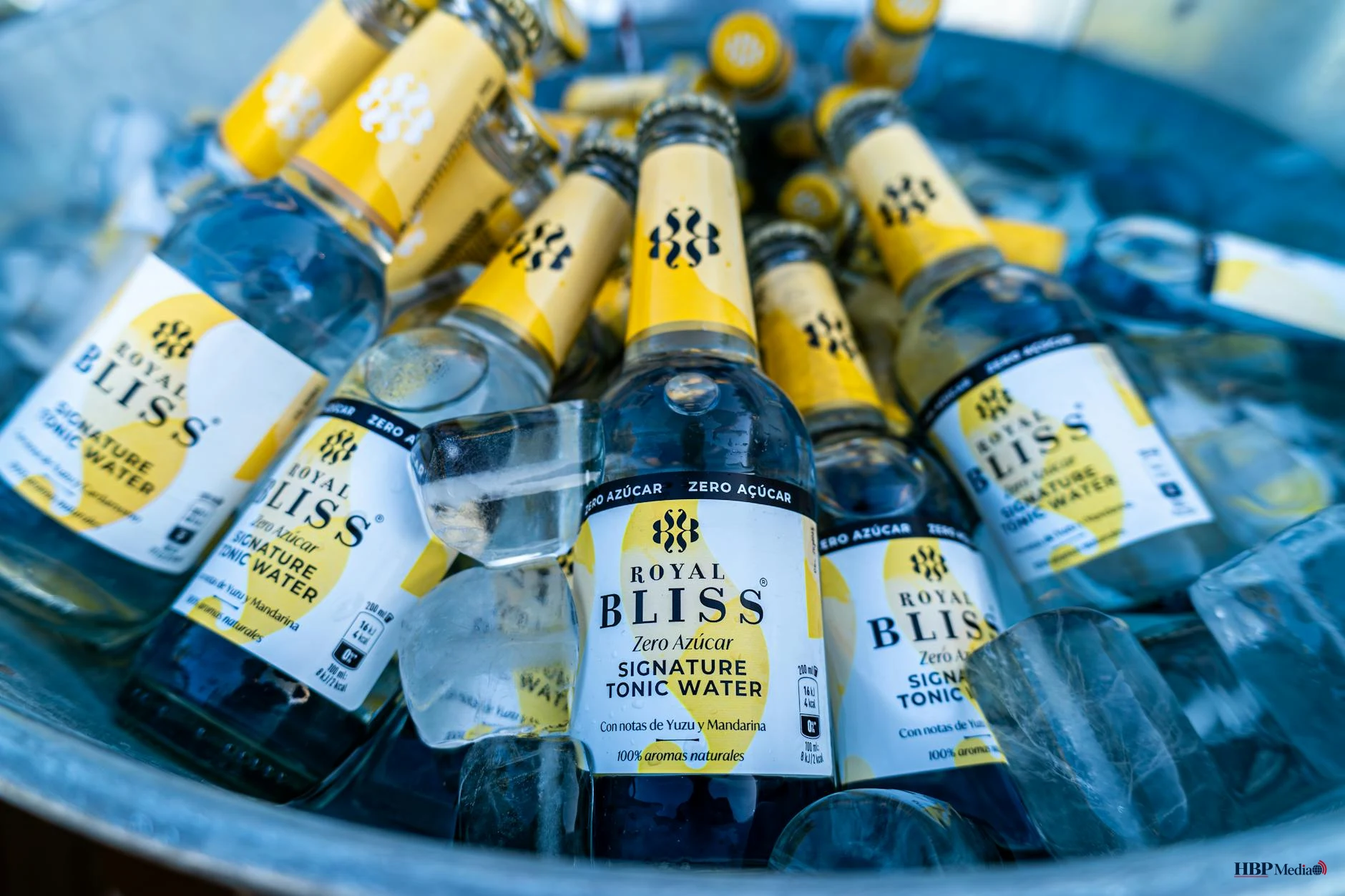 Een persoon schenkt een glas alcoholvrij bier in op een zonnig terras