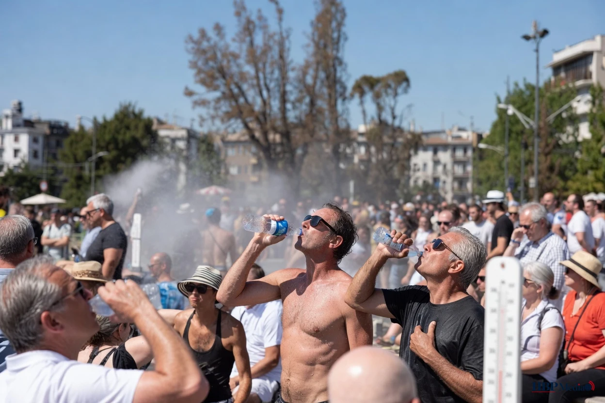 Mensen zoeken verkoeling en drinken water tijdens extreme hitte