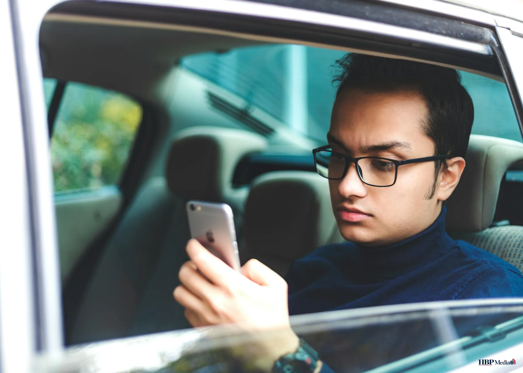 Een bestuurder die tijdens het autorijden een smartphone gebruikt met risico op een ongeval.