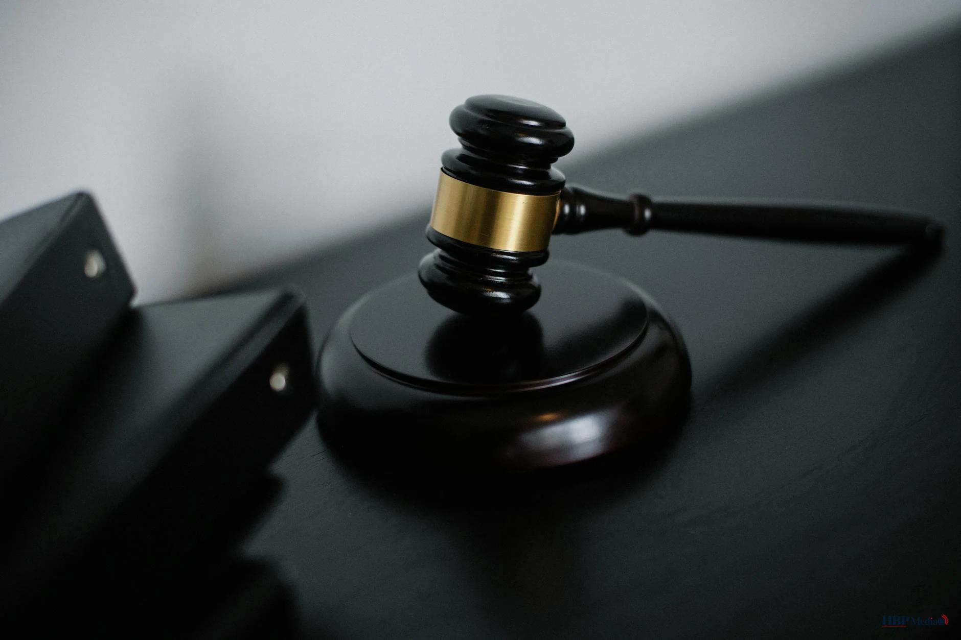 Jonge verdachte met gebogen hoofd in een Nederlandse rechtszaal, zittend naast zijn advocaat, met op de achtergrond de rechter aan de zittingsbank.