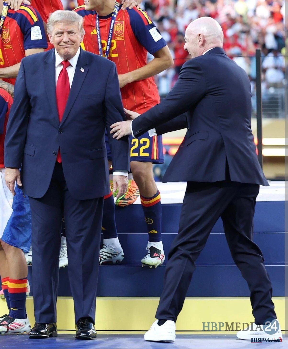 Donald Trump wordt door de FIFA-voorzitter van het podium getrokken tijdens de viering van wereldkampioen Spanje.