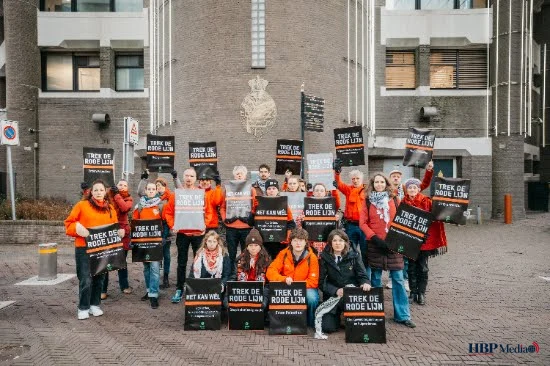 Demonstranten in rood tijdens Rode Lijn-actie voor bescherming internationaal recht