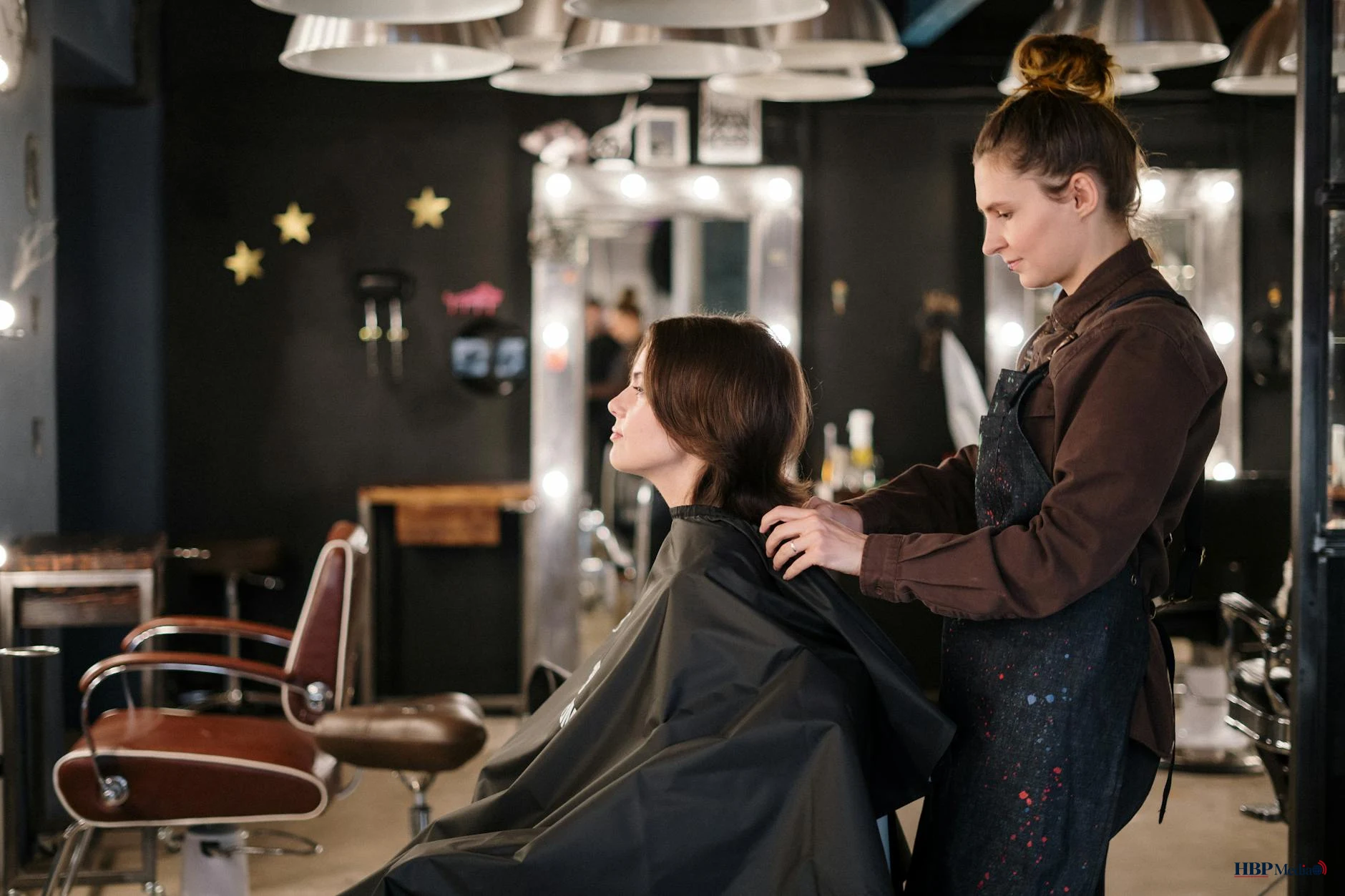 Een kapper in gesprek met een klant in de salon over persoonlijke zorgen.