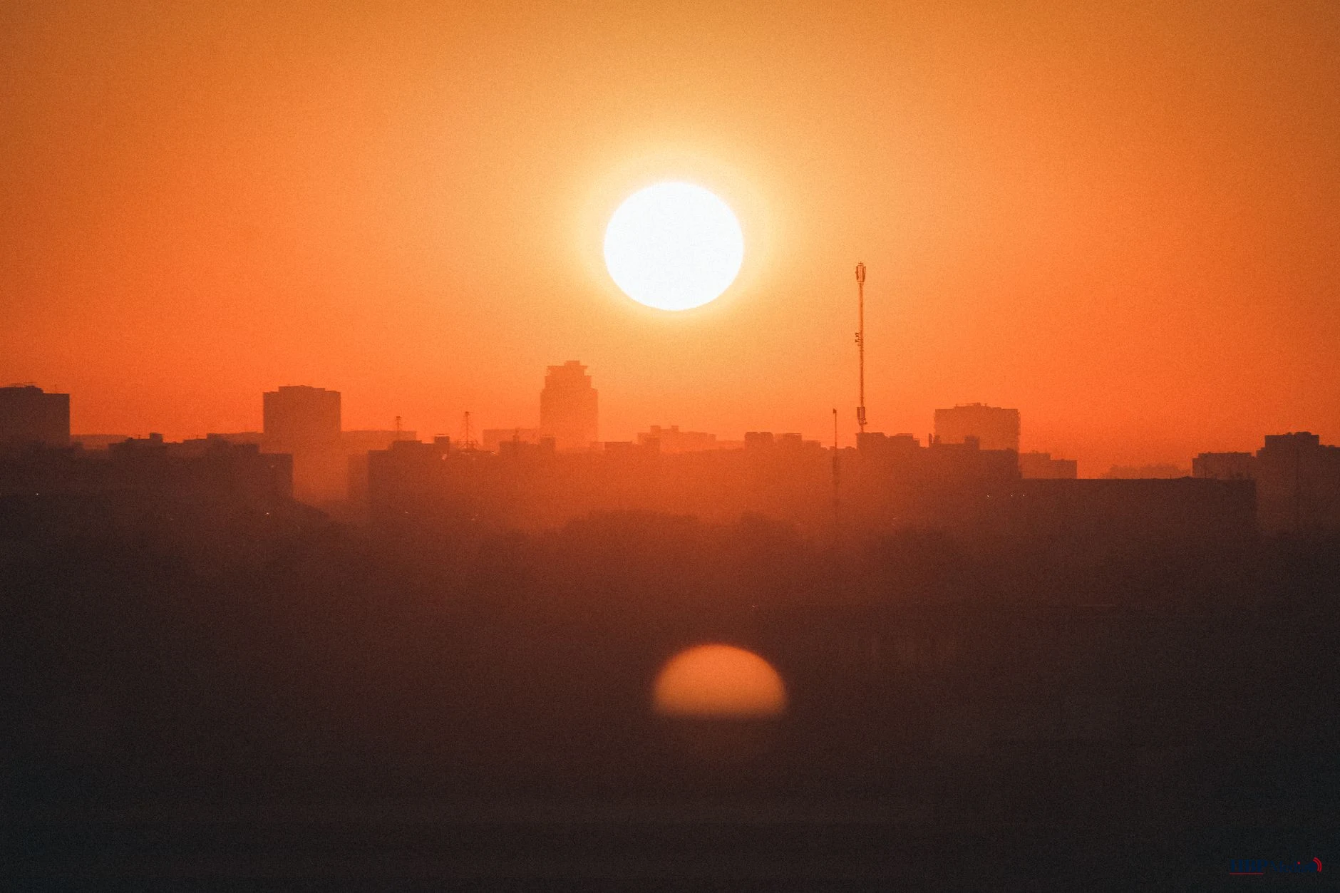 sunset with orange sky over a city