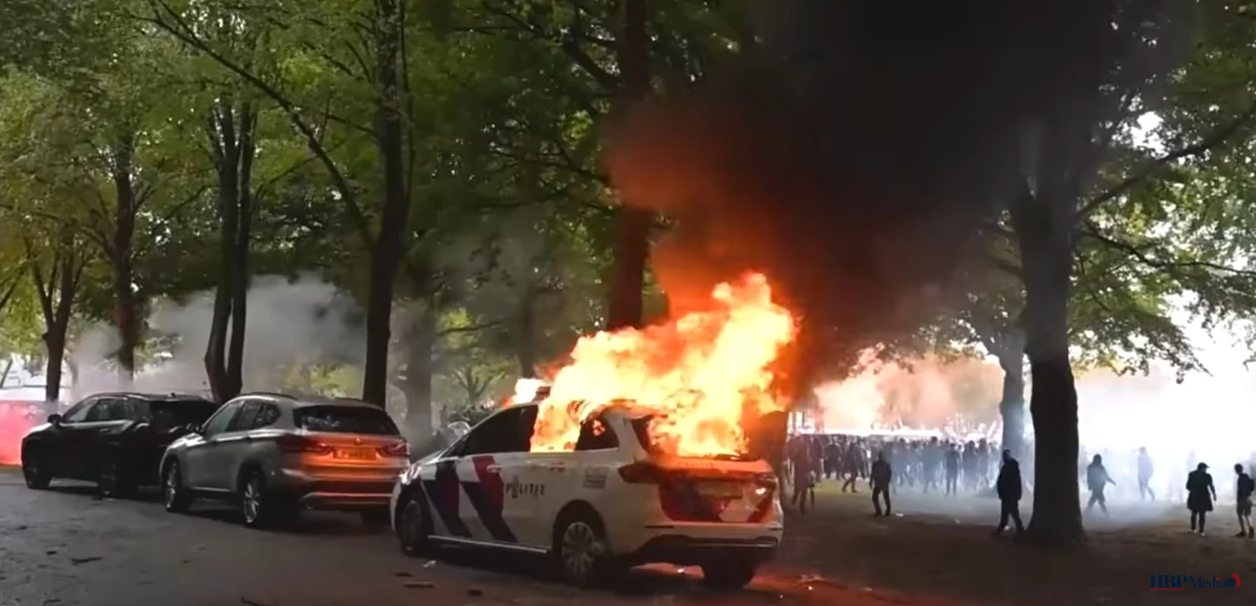 Brandende politieauto tijdens rellen op het Malieveld in Den Haag