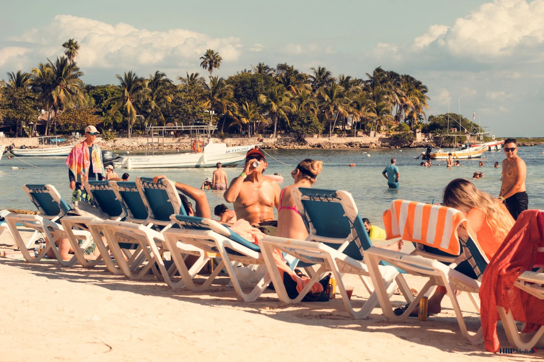 people on sunbeds by the shore