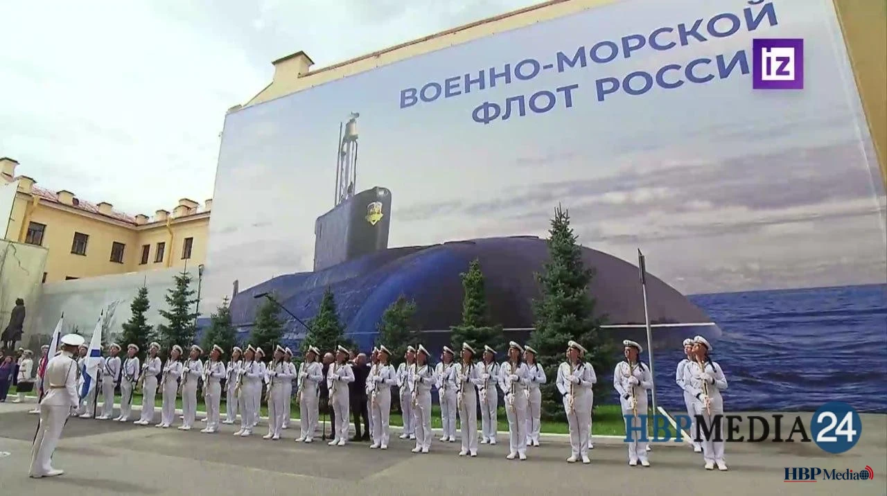Vladimir Poetin houdt een toespraak tijdens de Russische Marinedag, met op de achtergrond een op een betonnen muur geschilderde onderzeeër.