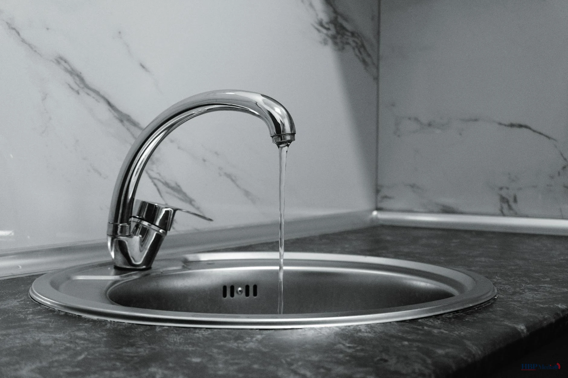Een stromende kraan met schoon drinkwater, symbool voor de Nederlandse drinkwatervoorziening die onder druk staat.