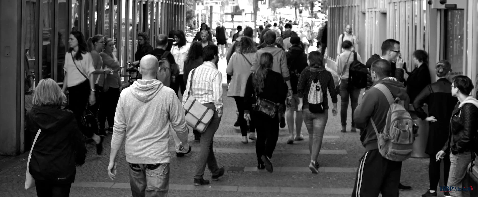 grayscale photography of people walking near buildings