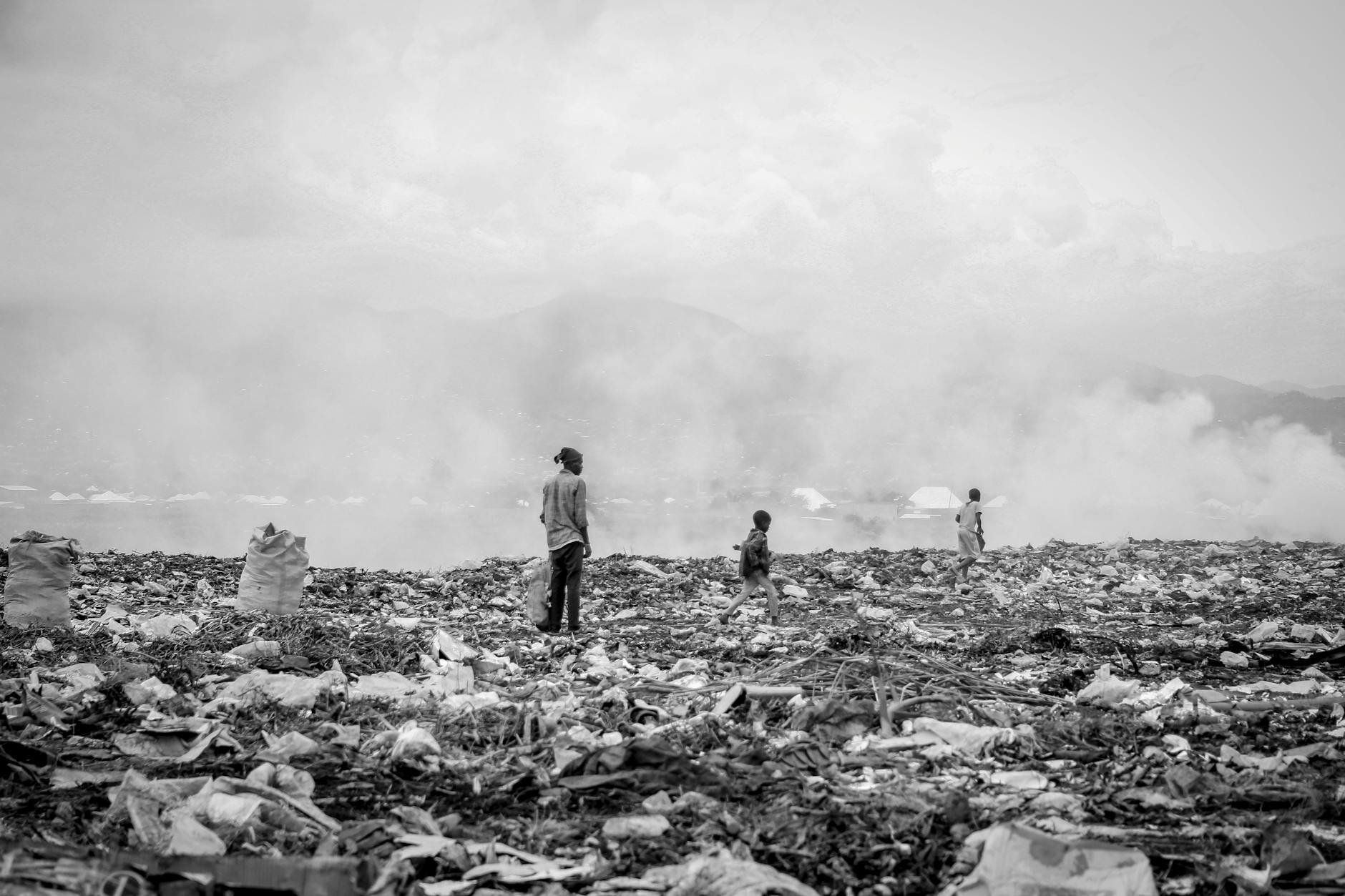 grayscale photo of people in the landfill site