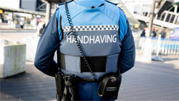 Buitengewoon opsporingsambtenaar in uniform tijdens controle in Nederlandse binnenstad.