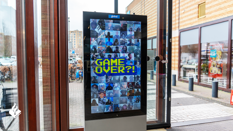 Bewakingsbeeld van een Game Over verdachte die geld opneemt bij een pinautomaat.