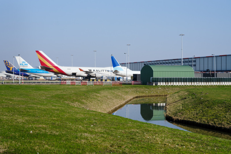 en luchtfoto van Schiphol waar onderzoek naar PFAS-verontreiniging in de bodem en het water wordt uitgevoerd.