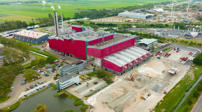 Vuilniswagen bij containers terwijl het kabinet belastingen op afvalverwerking verhoogt